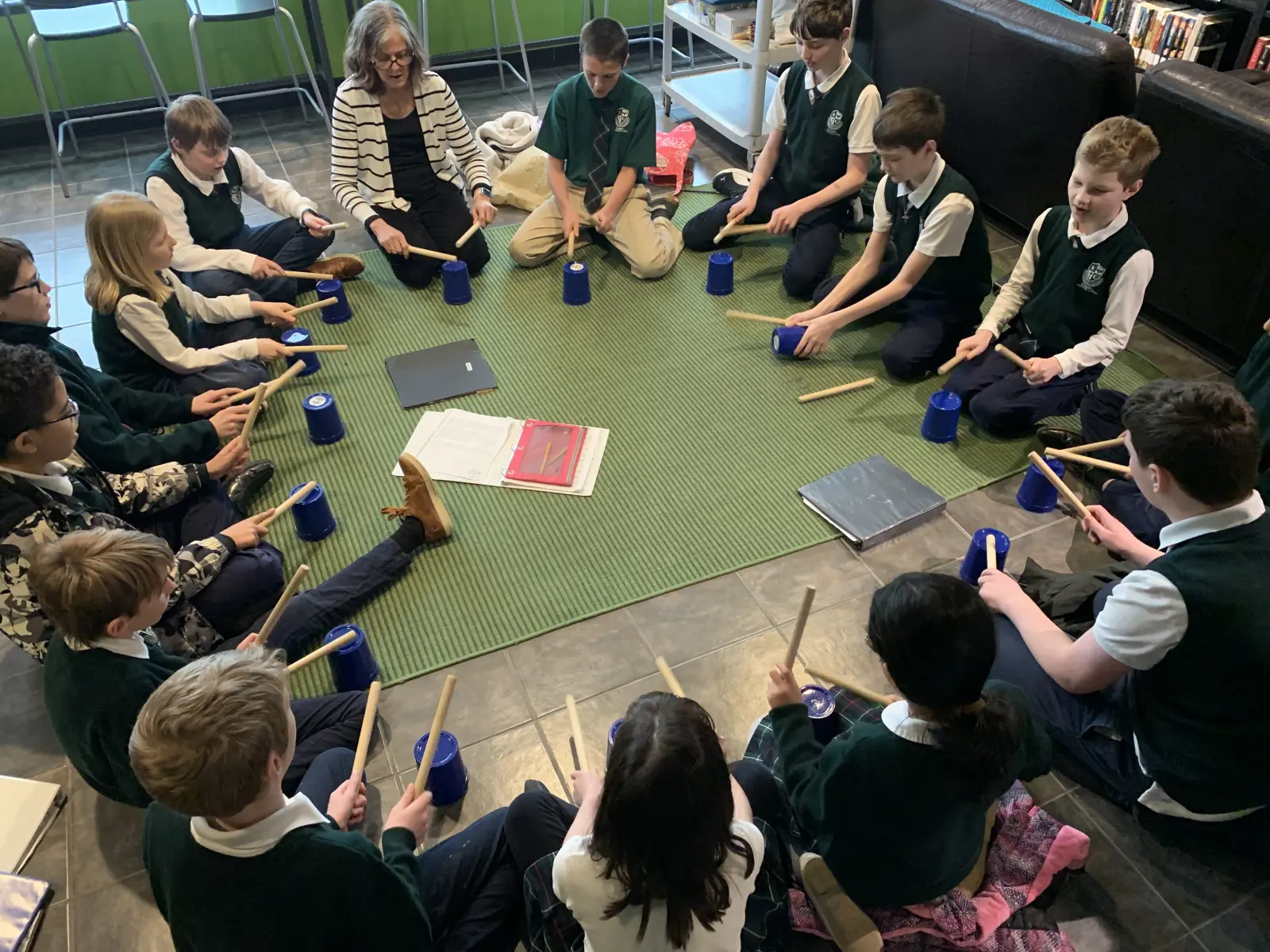 Kardia students learning rhyth using buckets as drums