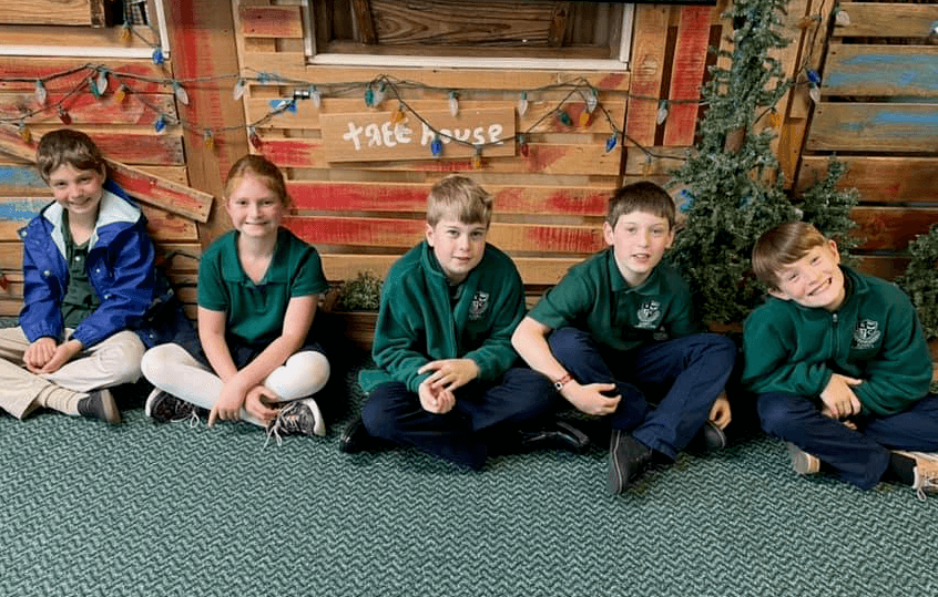 Five children sitting on floor in Kardia Classical uniforms