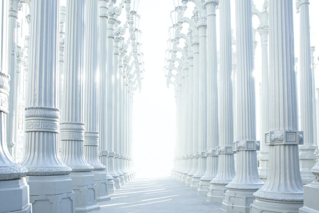 Rows of pillars with bright sun in the background