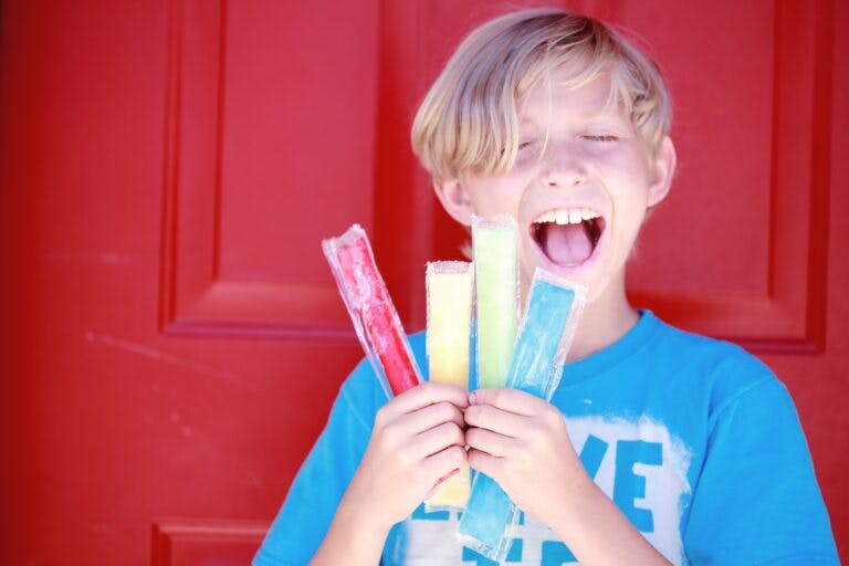 Happy child holding popsicles